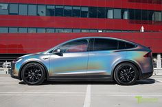 a silver car parked in front of a red building