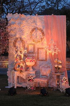 an outdoor wedding setup with chairs and lights