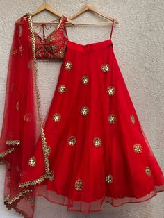 This red mirror lehenga is covered with embroidered butis.  It is paired with an intricately hand embellished blouse.  The outfit is completed with a tulle dupatta with butis and cutwork border. Mirror Lehenga, Mirror Work Lehenga, Lehnga Dress, Bridal Lehenga Red, Half Saree Designs, Red Mirror, Red Lehenga, Indian Lehenga, Embellished Blouse