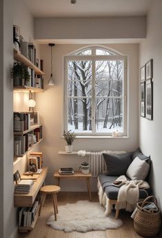 a living room with a couch, bookshelf and large window in it's corner