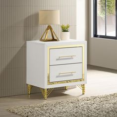 a white and gold nightstand with a plant on it next to a window in a room