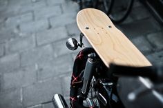 a wooden skateboard mounted to the back of a motorcycle