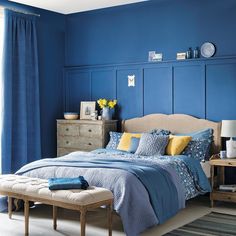 a bedroom with blue walls and yellow accents