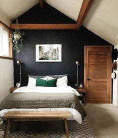 a bedroom with black walls, white bedding and green accents on the headboard