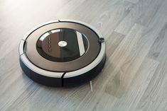 a robotic vacuum on the floor with its lid open