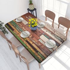 a table with plates and flowers on it in a room next to a potted plant