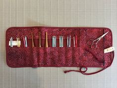 a red case holds several different types of knitting needles