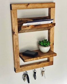 a wooden shelf with keys and a potted plant on it, hanging from the wall