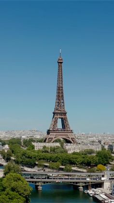 the eiffel tower towering over the city of paris, france with boats in the river below