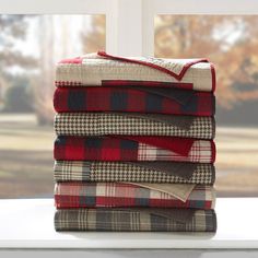 a stack of blankets sitting on top of a window sill