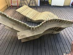 a wooden bench sitting on top of a wooden floor next to a person's feet