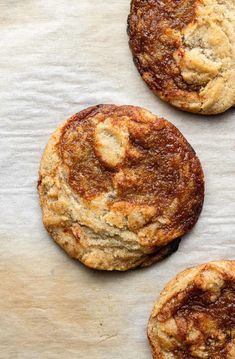 three cookies sitting on top of a piece of parchment paper