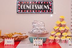 a table topped with lots of food next to a sign that says concessiones on it