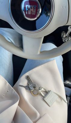 the interior of a car with a steering wheel and keychain attached to it