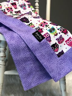 two purple owls and polka dots baby blankets on a white chair