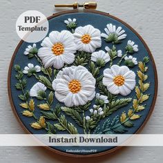 an embroidery pattern with white daisies and green leaves on a blue background that reads instant download