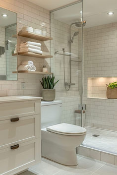 a white toilet sitting in a bathroom next to a walk in shower with glass doors