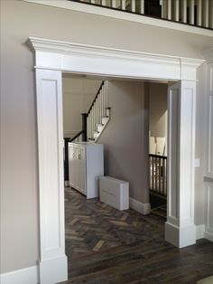 an empty room with some boxes in the middle and stairs leading up to the second floor