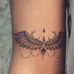 a black and white tattoo design on the ankle, with an angel wing in the center