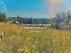 a field with grass, flowers and trees in the background that says i like being around people who let me be quiet