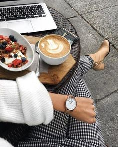 a person sitting at a table with a plate of food and a cup of coffee