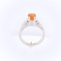 Gorgeous orange Spessartite Garnet set in a delicate modern regal setting. This ring features a hint of vintage and a lot of color. Oval 6x4mm Fancy Spessartite Garnet totals 1.48ct Setting totals 1/8ct diamonds 14k White Gold, ornate filigree detailing Size 7 - Free sizing available Please contact us to learn more or schedule a virtual appointment! Luxury Orange Gemstone Ring, Elegant Citrine Solitaire Ring, Elegant Solitaire Citrine Ring, Orange Round Jewelry With Brilliant Cut, Orange Sapphire Ring For Formal Occasions, Elegant Citrine Solitaire Jewelry, Orange Oval Sapphire Gemstone Ring, Fine Jewelry Orange Sapphire Anniversary Ring, Elegant Citrine Diamond Ring With Center Stone