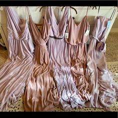 four bridesmaid dresses hanging on a rack