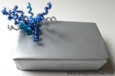 a silver present box with blue decorations on it