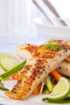 a white plate topped with fish and veggies