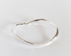 Irregular silver bracelet.   Its modern design makes it a perfect gift for strong woman. This wavy bangle is made of an  hypoallergenic alloy and silver plated (10 micron) to give its polished shiny look.  I made it in my Spain workshop with high quality materials which ensures a perfect finish with great durability. It is an easy wear piece of jewelry that you can rock both with jeans or a cocktail dress.  🎁This stackable bracelet is also available in yellow gold https://www.etsy.com/listing/1 Modern Sterling Silver Bracelet As Gift, Silver Bangle With A Modern Twist, Modern Twist Sterling Silver Bracelet For Gift, Modern Twist Sterling Silver Bracelet Gift, Sterling Silver Bangle With A Modern Twist, Modern Twist Sterling Silver Bracelet As Gift, Modern Handmade Bangle As A Gift, Handmade Modern Bangle As Gift, Modern Twist Silver Bangle Bracelets