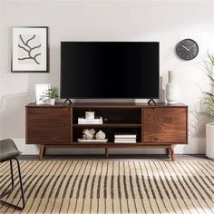 a flat screen tv sitting on top of a wooden entertainment center in a living room