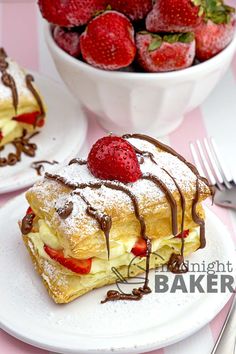 strawberry shortcakes with chocolate drizzle and strawberries in a bowl on the side