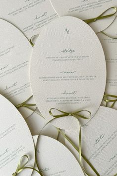 the wedding stationery is laid out on top of each other, with ribbons tied around them