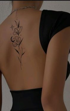 the back of a woman's body with flowers tattooed on her upper and lower back