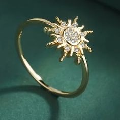 a diamond sunburst ring on a green surface