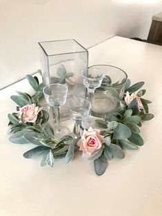 a table topped with glasses and flowers on top of it