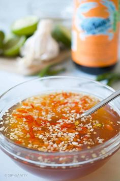 a glass bowl filled with soup next to a bottle