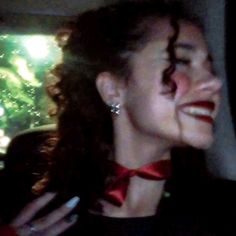 a woman wearing a red bow tie sitting in a car