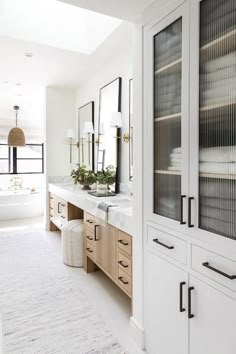 a large bathroom with white walls and cabinets