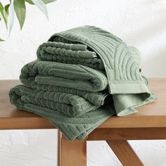 a stack of folded towels sitting on top of a wooden table