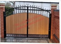 an iron and wood gate with brick walls