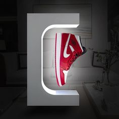 a pair of red and white sneakers are on display in the shape of a letter