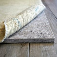 a close up of a rug on the floor with a wooden floor in the background