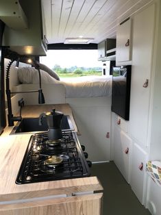 the interior of a camper with a stove top oven and sink in front of it