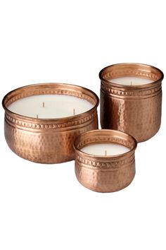 three copper - plated candles are sitting next to each other on a white background