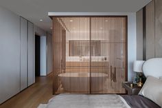 a bed sitting in a bedroom next to a wooden slatted wall on top of a hard wood floor