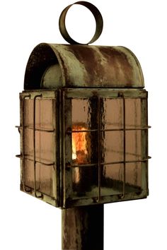 an old fashioned lantern with a lit candle in the center on a post, isolated against a white background