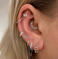 a woman's ear with three different types of piercings