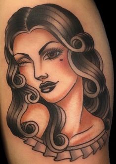 a woman's face with long hair and curls on her arm, done by tattoo artist