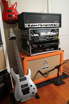 an electric guitar, amp and amp sitting on top of each other in a room